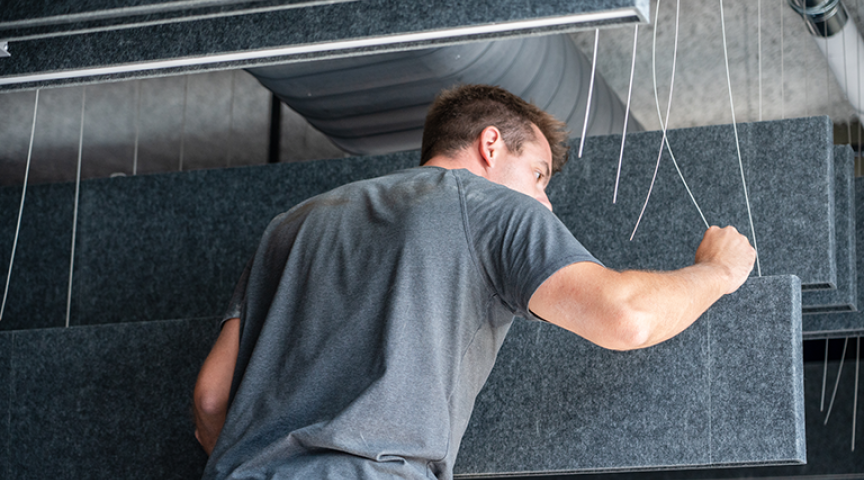 Installer hangs Seem 1 Acoustic PET baffles in ceiling